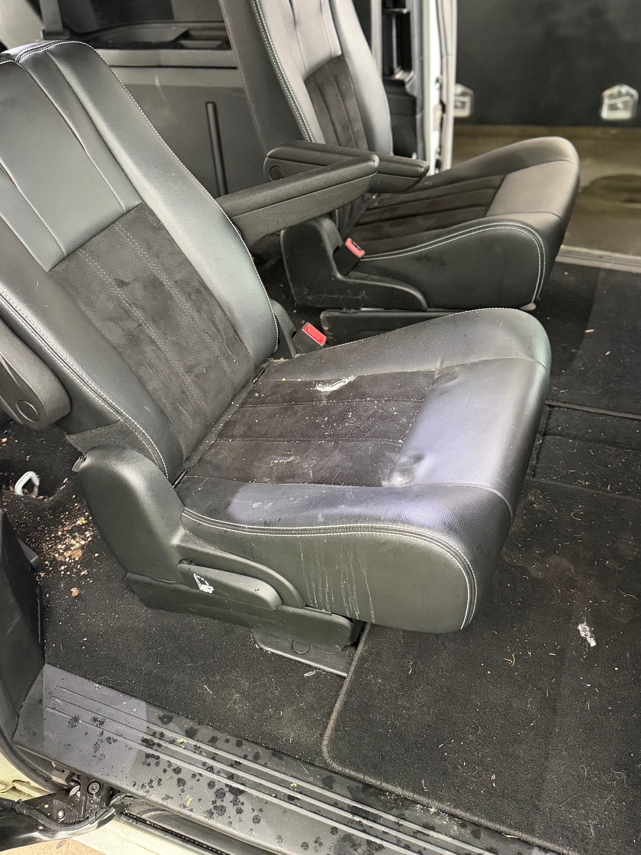 Before — dirty minivan mid-row seats with debris