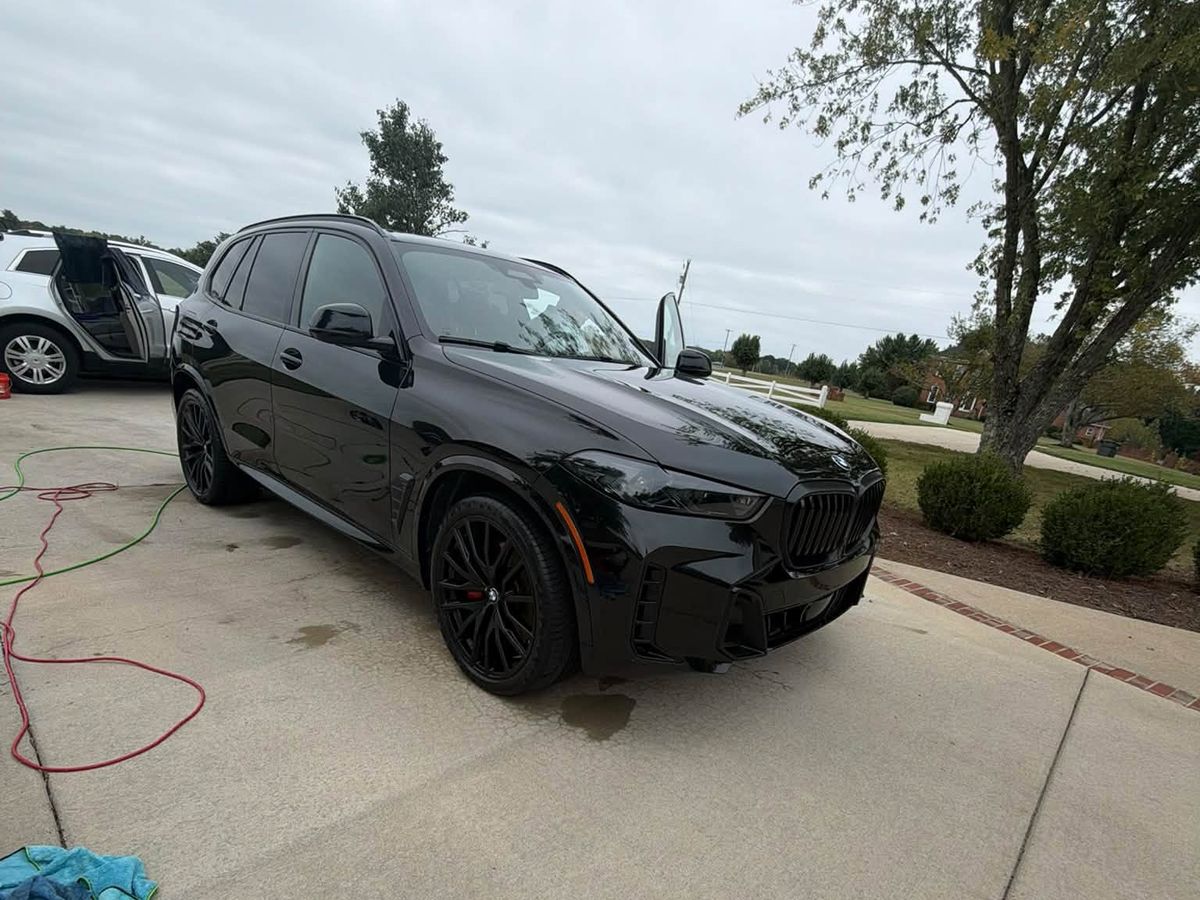 Black BMW X5 in a driveway after an exterior detail