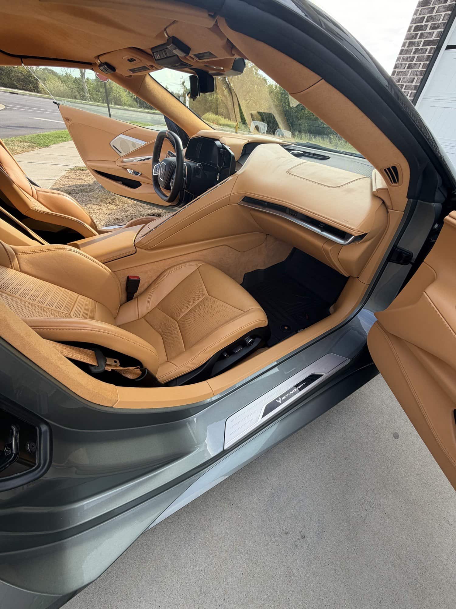 Tan leather interior of a Corvette C8 through the open door