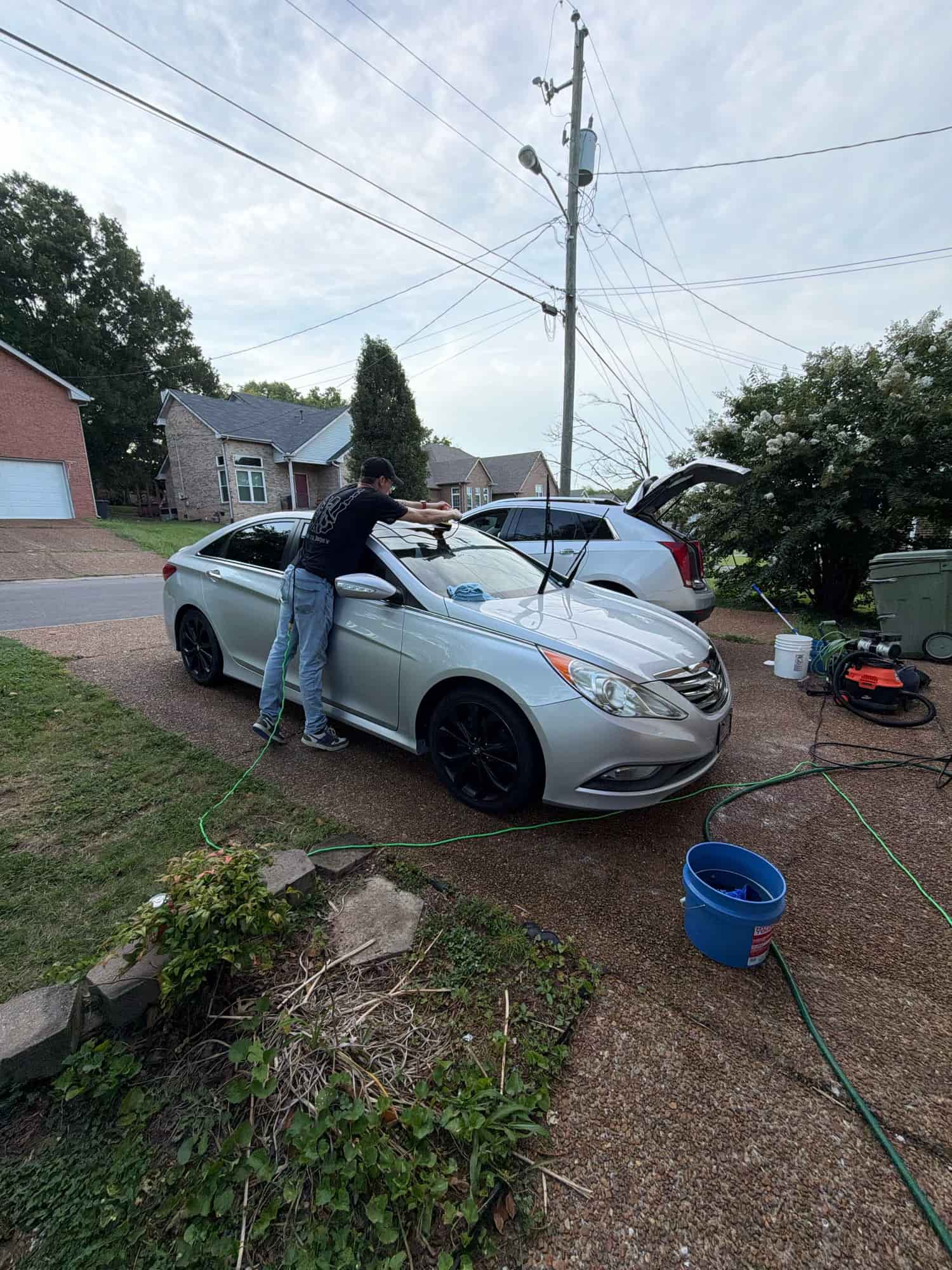Dylan polishing a Hyundai Sonata in a driveway