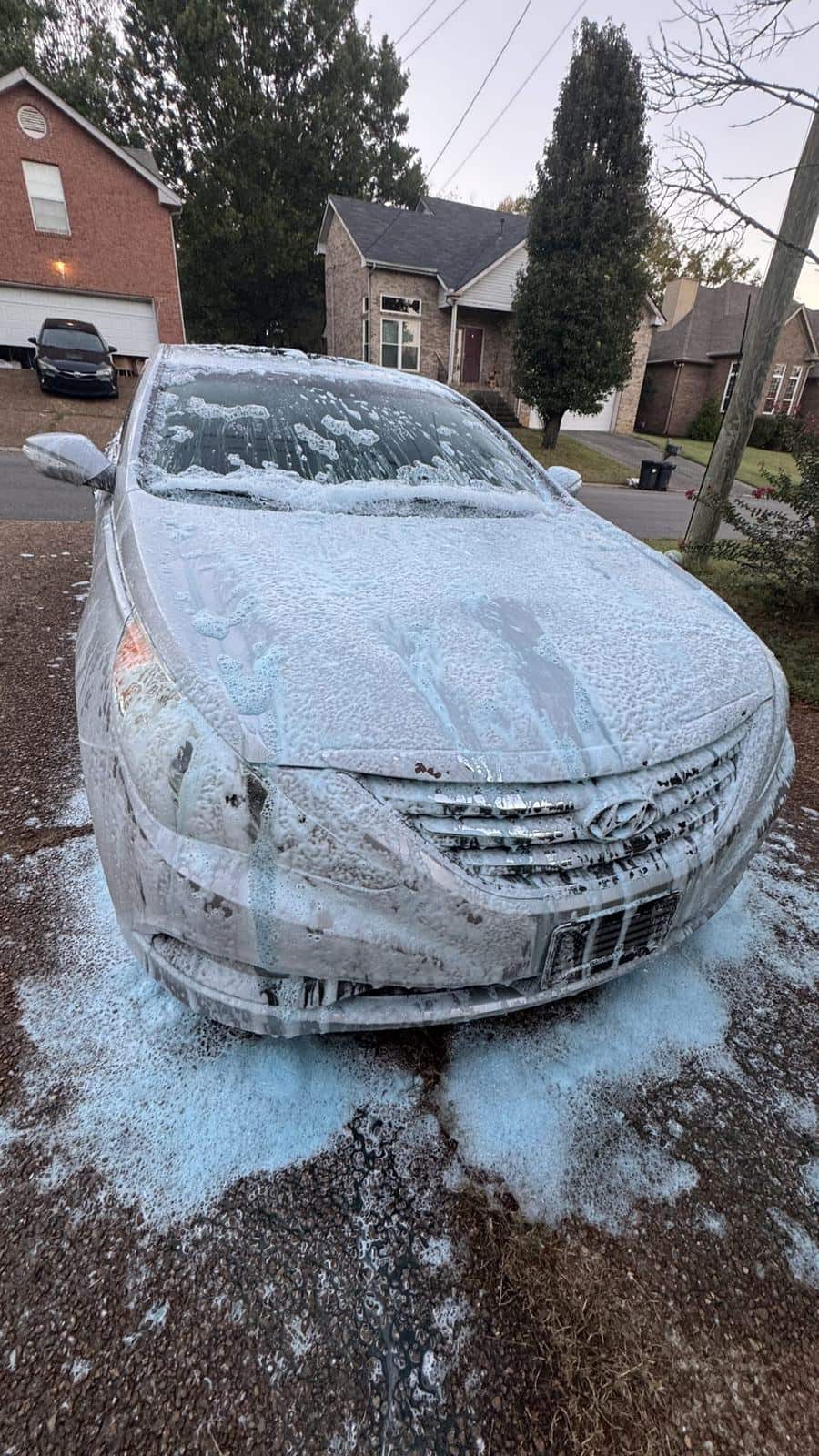 Silver Hyundai Sonata covered in blue foam, seen from the front