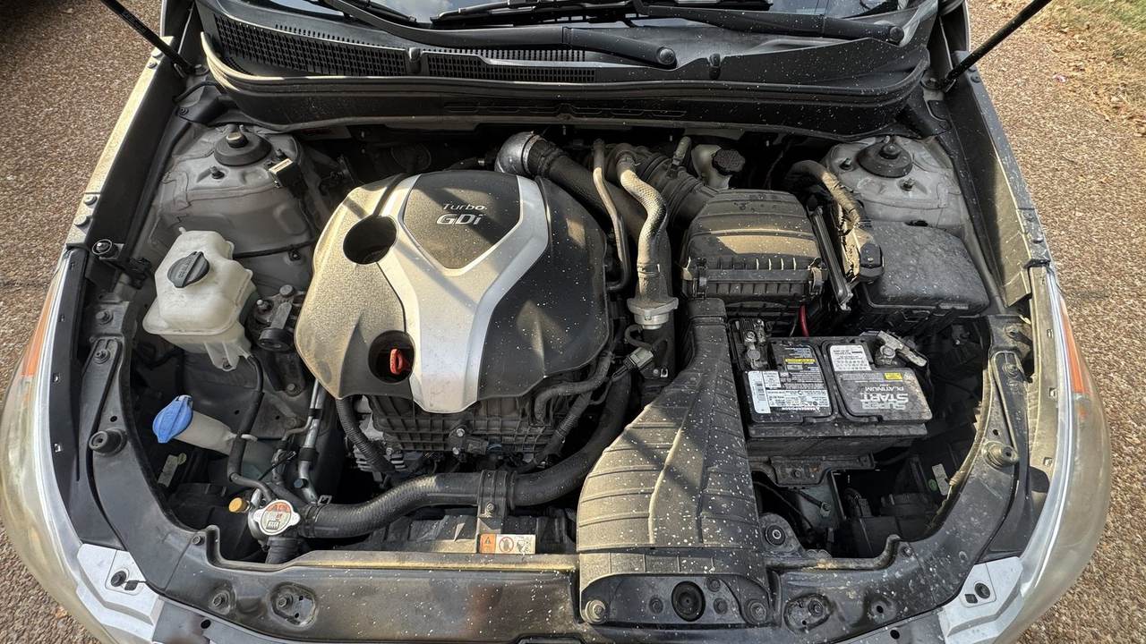 Before: dusty 2014 Hyundai Sonata 2.0T engine bay with leaves and grime on the cover and hoses.