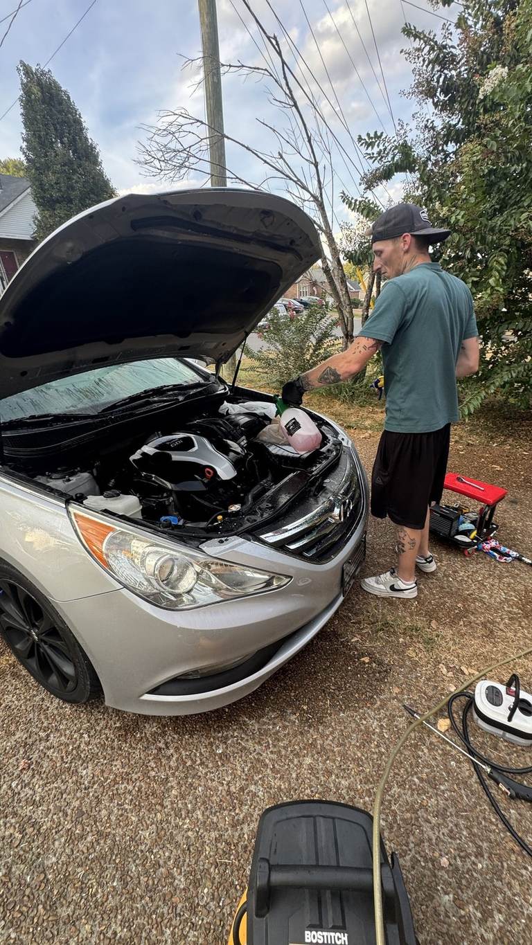 White degreaser on the engine cover and hoses of a 2014 Hyundai Sonata 2.0T, with plastic bags still over the electrics.