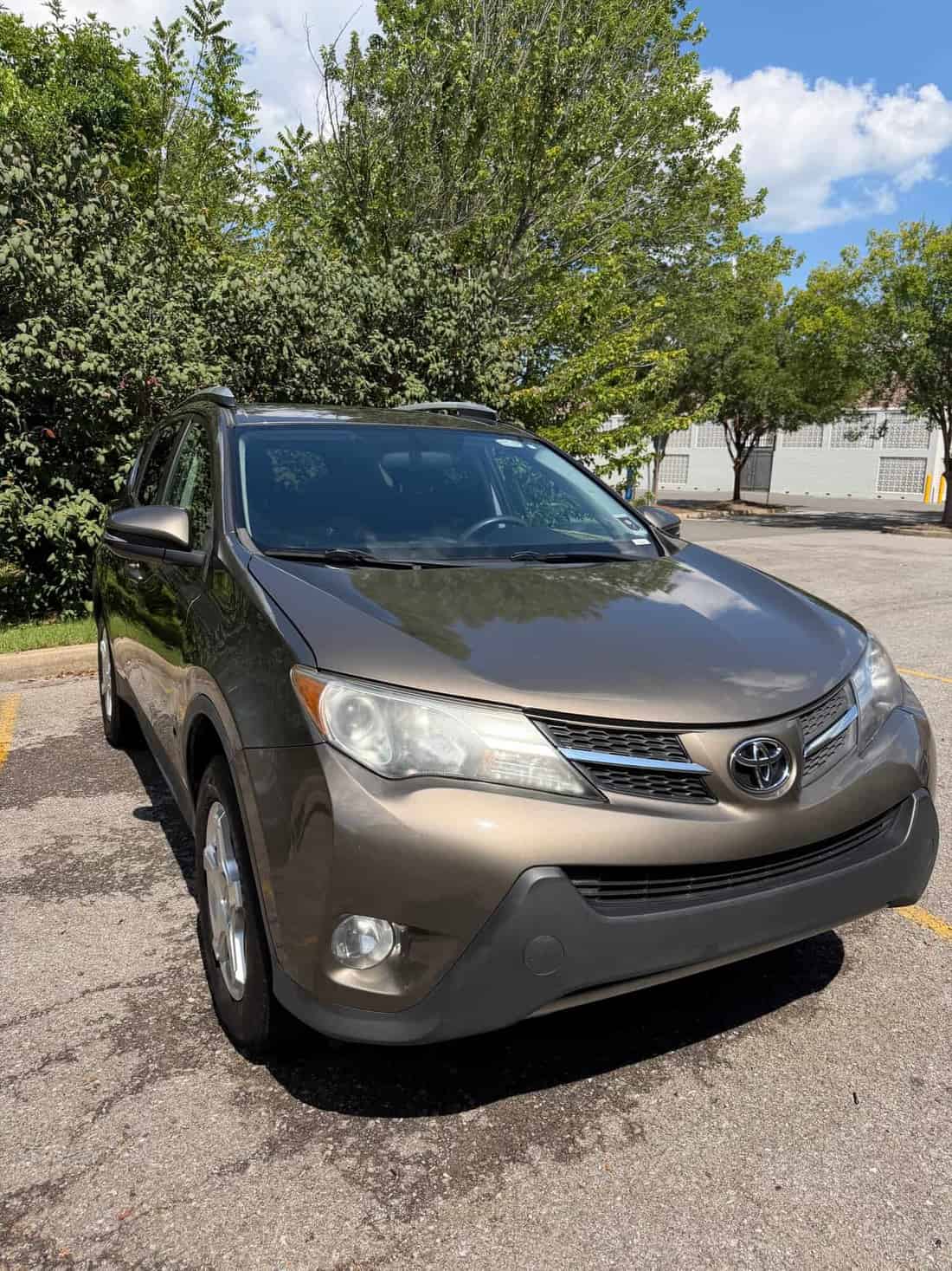 Brown Toyota RAV4 in a parking lot after a wash